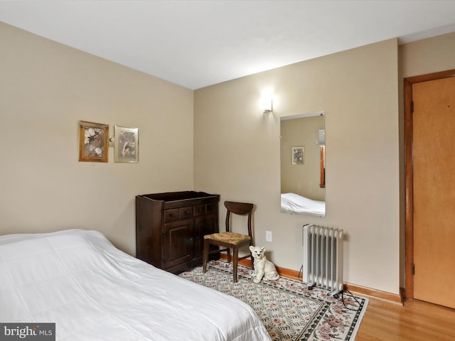 bedroom with light wood-type flooring and radiator