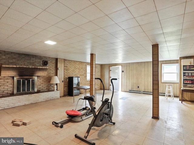 exercise area featuring a fireplace and wooden walls