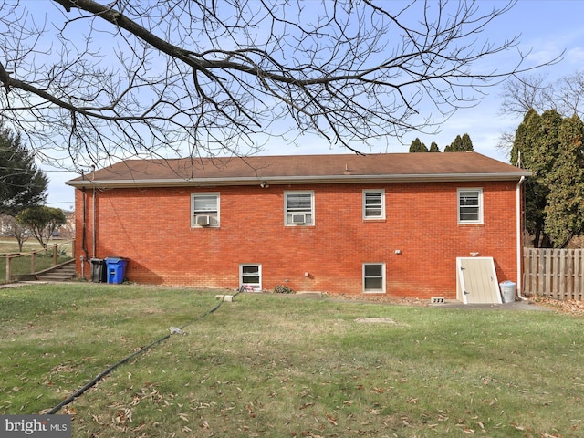 rear view of property with a lawn and cooling unit