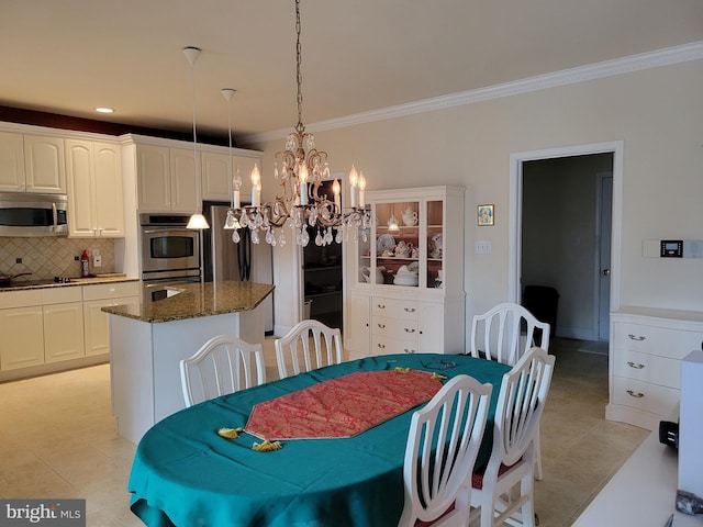 dining space with a chandelier, light tile patterned floors, and ornamental molding