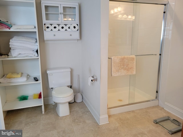 bathroom featuring toilet and a shower with door