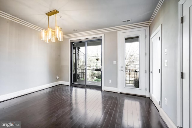 entryway with a chandelier, dark hardwood / wood-style flooring, and ornamental molding