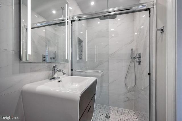 bathroom with vanity, an enclosed shower, and tile walls