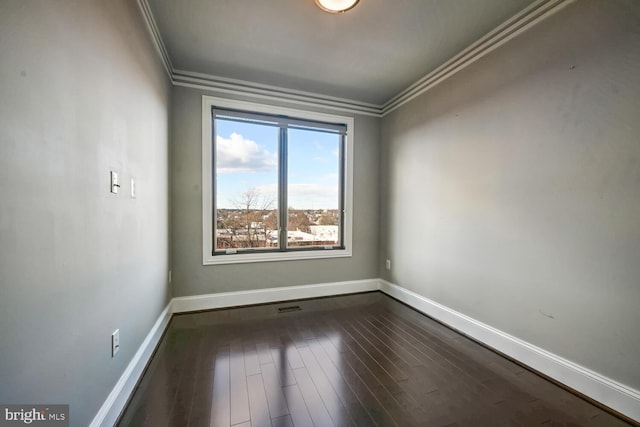 empty room featuring hardwood / wood-style flooring and crown molding