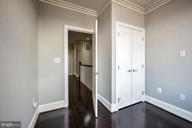 unfurnished bedroom with dark hardwood / wood-style flooring and crown molding