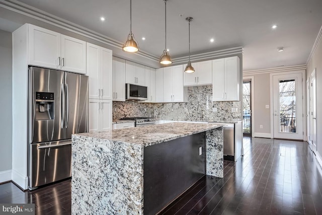 kitchen with light stone countertops, stainless steel appliances, white cabinets, a center island, and dark hardwood / wood-style floors