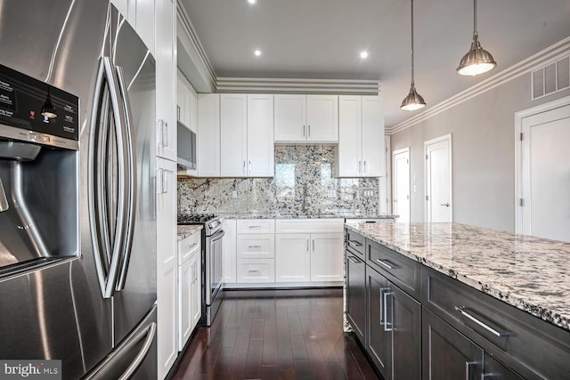 kitchen with stainless steel appliances, dark wood-type flooring, crown molding, decorative light fixtures, and white cabinetry