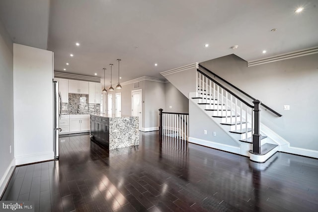 unfurnished living room with crown molding and dark wood-type flooring