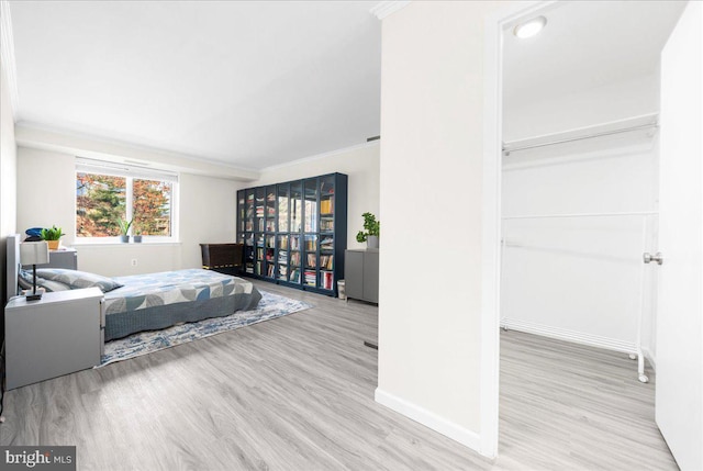 bedroom with light wood-type flooring and ornamental molding