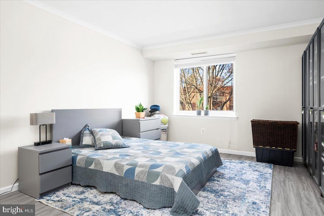 bedroom featuring crown molding and light hardwood / wood-style flooring