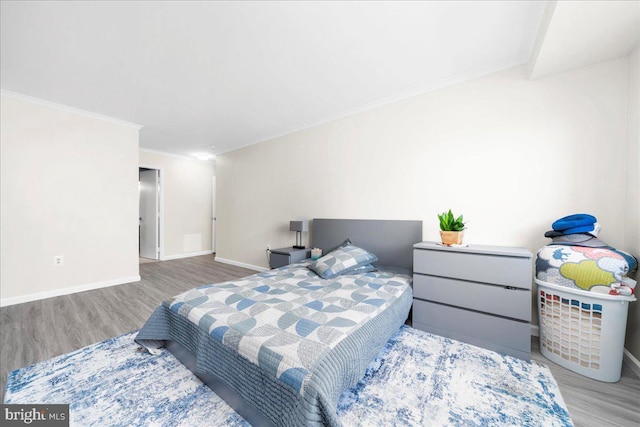 bedroom featuring light hardwood / wood-style flooring and crown molding