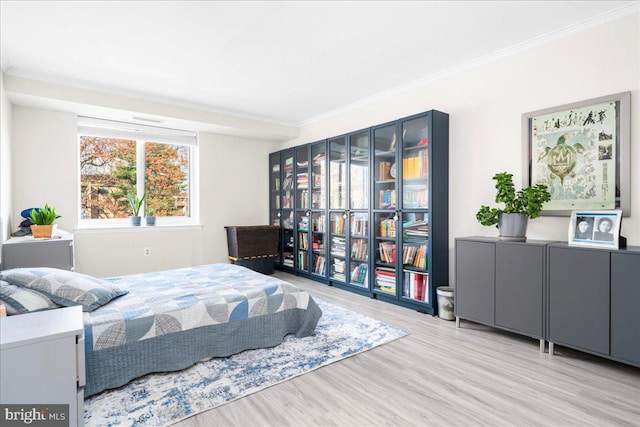 bedroom featuring light hardwood / wood-style floors and crown molding