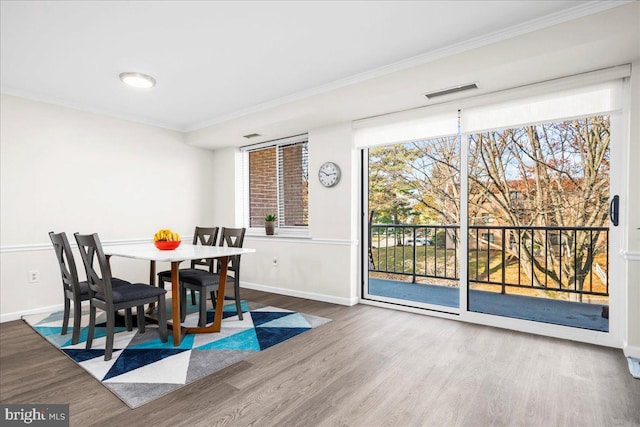 dining room featuring wood-type flooring and ornamental molding