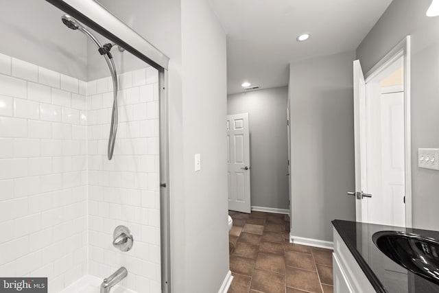 full bathroom featuring vanity, tiled shower / bath combo, tile patterned floors, and toilet