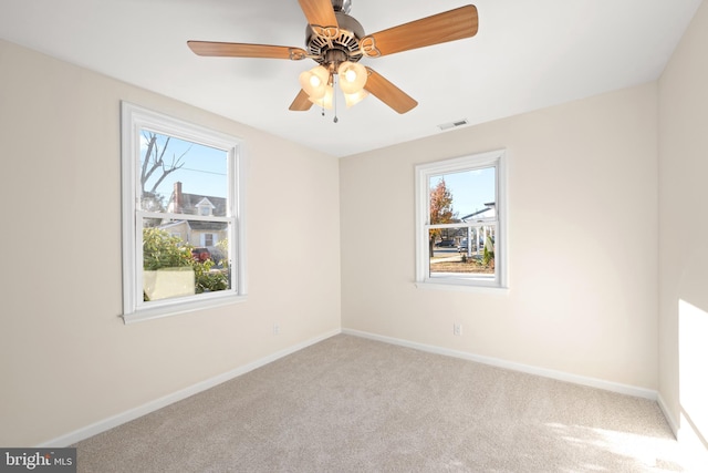 empty room featuring light carpet, plenty of natural light, and ceiling fan