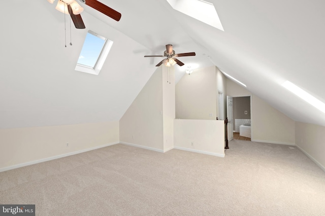 bonus room with light colored carpet, ceiling fan, and vaulted ceiling with skylight