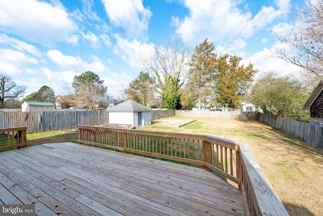 deck featuring a garage, an outdoor structure, and a yard