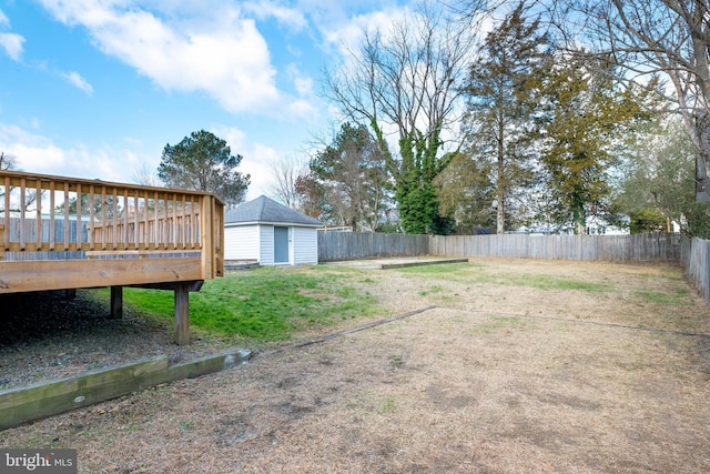 view of yard with a wooden deck and a storage unit