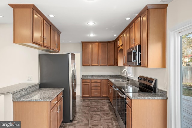 kitchen with light stone countertops, sink, and appliances with stainless steel finishes