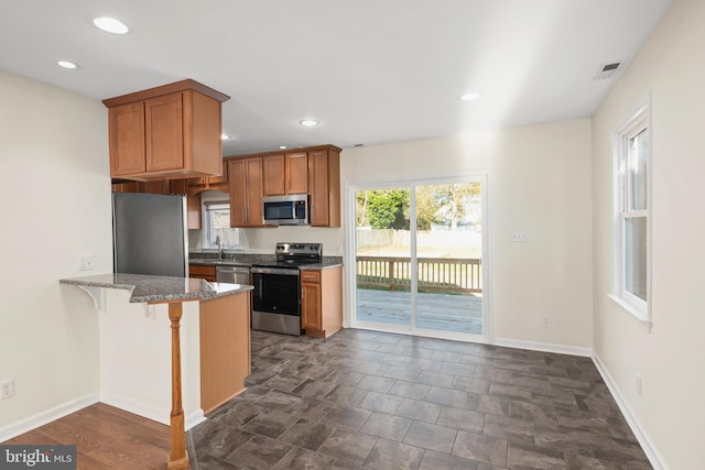 kitchen featuring a breakfast bar, appliances with stainless steel finishes, kitchen peninsula, and sink