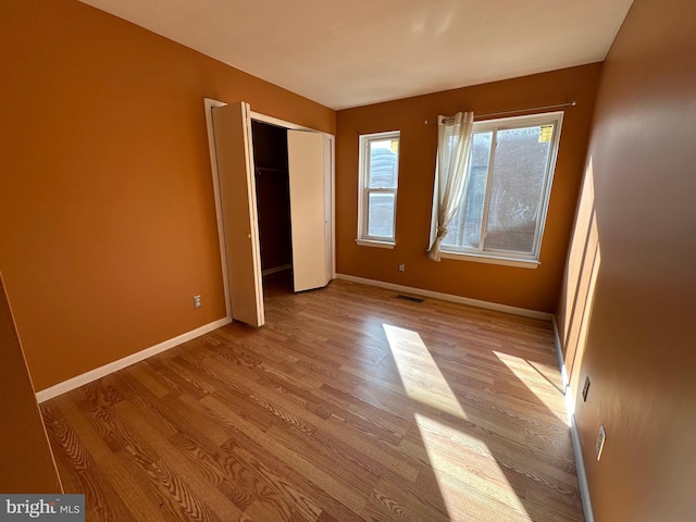 unfurnished bedroom featuring a closet and light hardwood / wood-style flooring