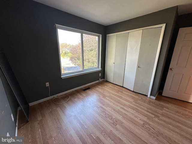 unfurnished bedroom featuring light hardwood / wood-style floors and a closet