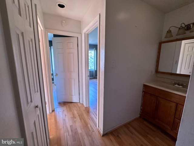 corridor with sink and light hardwood / wood-style floors