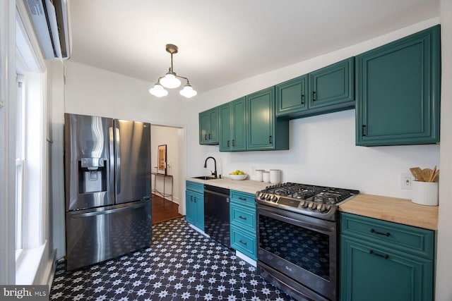 kitchen with appliances with stainless steel finishes, green cabinetry, pendant lighting, and sink