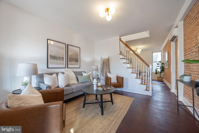 living room featuring a wall mounted air conditioner, dark hardwood / wood-style flooring, brick wall, and an inviting chandelier