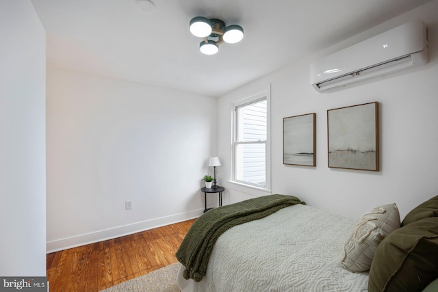 bedroom featuring an AC wall unit and wood-type flooring