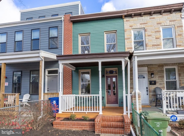 townhome / multi-family property featuring covered porch