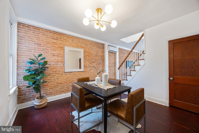 dining room featuring a wall mounted AC, a chandelier, dark wood-type flooring, and brick wall