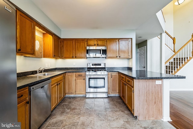 kitchen with sink, light hardwood / wood-style flooring, kitchen peninsula, a breakfast bar, and appliances with stainless steel finishes