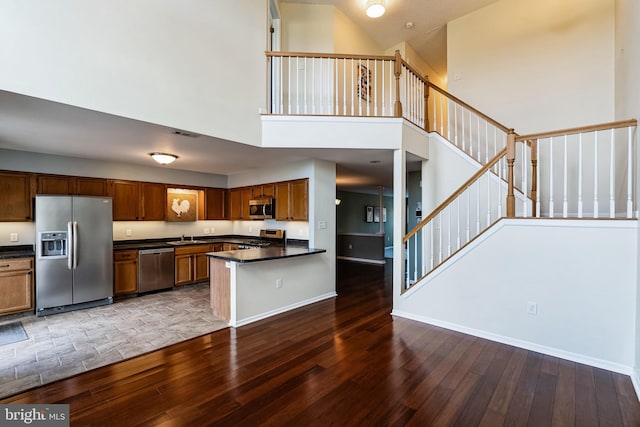 kitchen featuring high vaulted ceiling, stainless steel appliances, and dark hardwood / wood-style floors