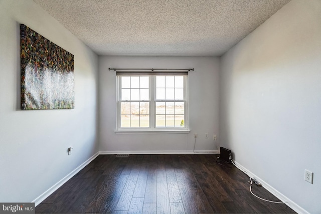 unfurnished room featuring a textured ceiling and dark wood-type flooring