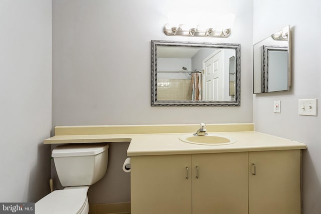 bathroom featuring curtained shower, vanity, and toilet