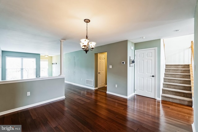 empty room with dark hardwood / wood-style flooring and a chandelier