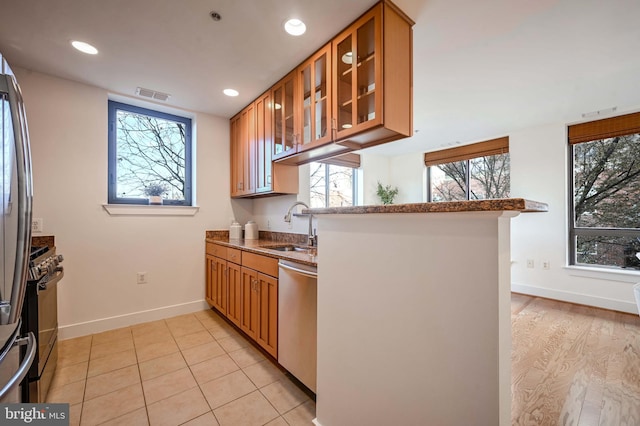 kitchen featuring plenty of natural light, sink, light tile patterned floors, and stainless steel appliances