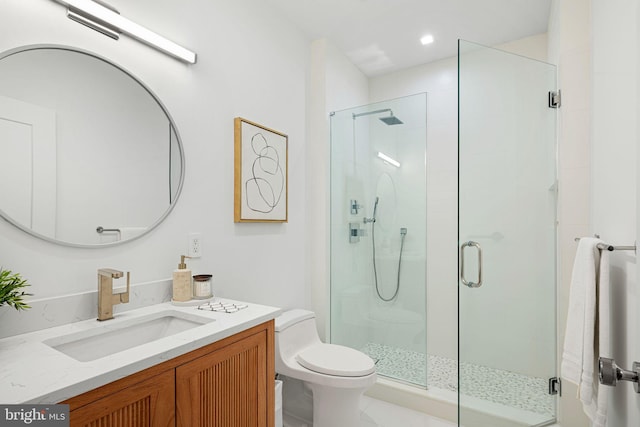 bathroom with an enclosed shower, vanity, and toilet