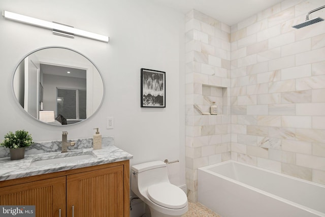 full bathroom featuring vanity, tiled shower / bath combo, and toilet