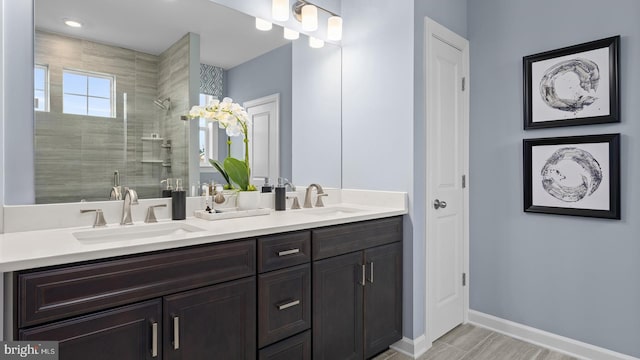 bathroom with hardwood / wood-style flooring, vanity, a healthy amount of sunlight, and walk in shower