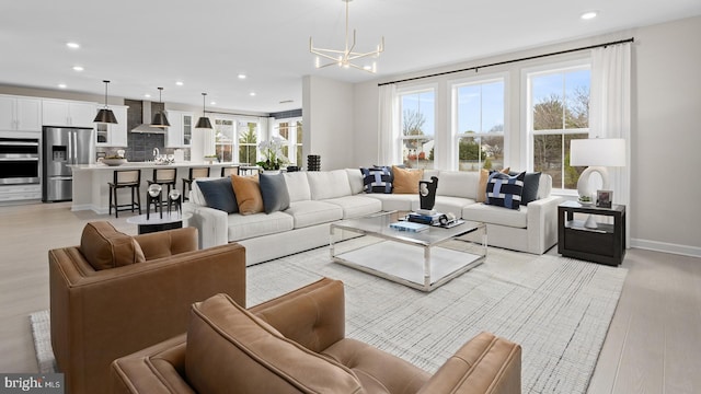 living room with light hardwood / wood-style flooring and an inviting chandelier