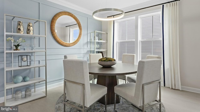 dining area with light hardwood / wood-style floors and ornamental molding