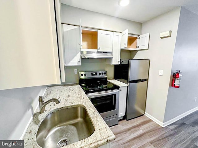 kitchen featuring light stone countertops, appliances with stainless steel finishes, light wood-type flooring, sink, and white cabinets