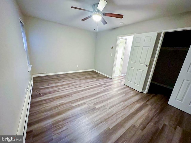 unfurnished bedroom featuring ceiling fan, light hardwood / wood-style floors, a walk in closet, and a closet