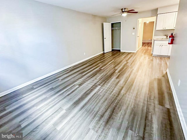 interior space with light wood-type flooring, ceiling fan, and sink