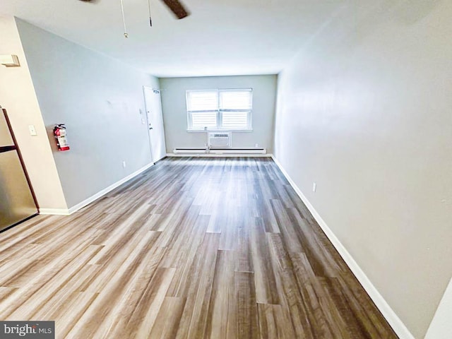 interior space featuring a wall mounted AC, light hardwood / wood-style floors, and ceiling fan