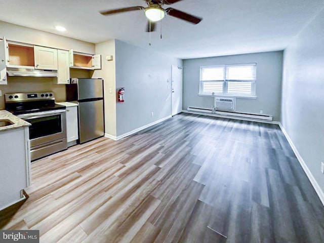 kitchen with baseboard heating, ceiling fan, stainless steel appliances, and light hardwood / wood-style floors