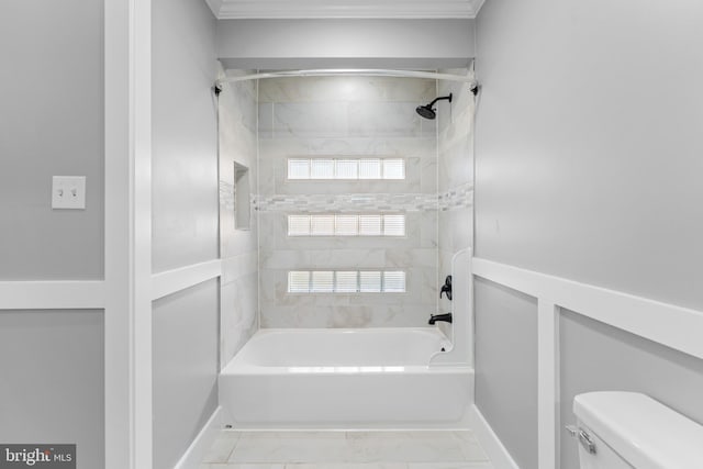 bathroom with a healthy amount of sunlight, toilet, ornamental molding, and tiled shower / bath