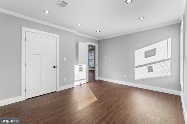 spare room with crown molding and dark wood-type flooring